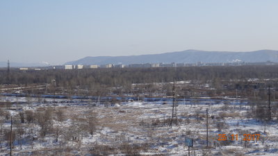 А это, ещё левее - в перспективе, с небольшим зумом, Ленинский округ, а в просто народии - Дзёмги. На Дзёгах живут Дзёмгинцы, потому что ещё помню с детства, как говорили - Дзёмгинцы, это не Городские... есть в них что то такое, более натуральное, что ли. А ещё, на Дзёмгах, делают самолёты. Причём как гражданские Супер Джет 100, так и всякие СУшки. А ещё, они там на Дзёмгах, на том что собрали, частенько летают, и через это. бывает, жутко шумят. И шумят не только в небе, но и на стендах двигателями. Так что мой пластик на окнах, наверно в километрах шести, не сильно то и спасает.<br />Дзёмги и Город, разделяет река Силинка - вон на фотке, почти сразу за ЖД насыпью, виден её заснеженный крутой левый берег. Силинка - это граница районов. Сразу за Силинкой, начинается Силинский парк. Но название парк, для этого лесистого участка, кто то придумал из прежних. На самом деле, это просто кусок не вырубленной тайги, и из культурного, там только тропинки и отдыхающие. И если вздумается прогуляться по этому парку, к примеру на север, то до самого Магадана, можно никого и не встретить более, из людей. Я живу недалеко от этих реки и парка, и летом, очень даже не прочь, погонять там на велике, а потом искупаться, уже перед самым домом. До реки от меня, где то метров 500 наверное.